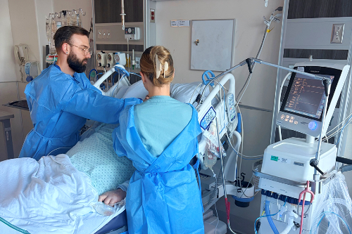 Un jeune homme et une jeune femme prennent soin d'un patient alité.