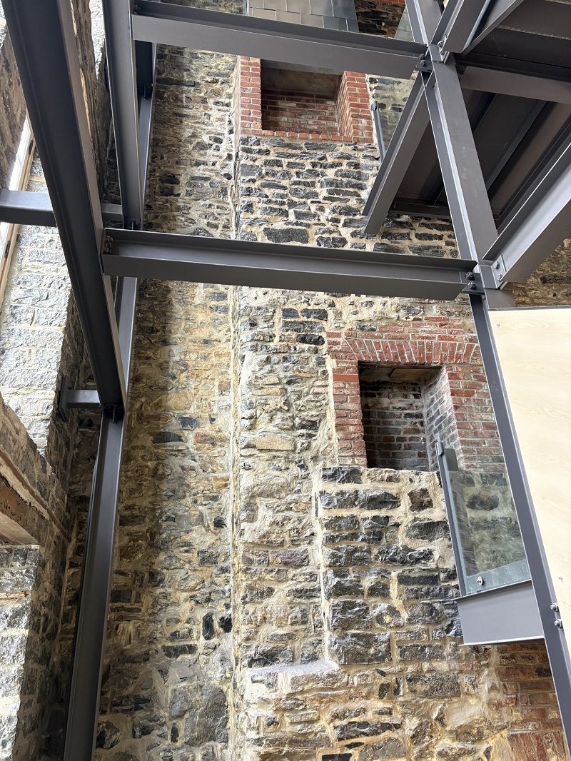 Photo d'un mur de pierres percé de deux cheminées.