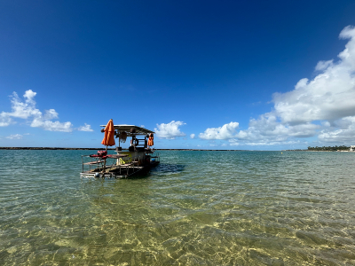 La plage de Muro Alto, à Ipojuca, dans l’état de Pernambuco. Source : Barbara Ramirez. Photo d'un bateau dans l'eau de la mer.