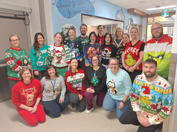 Des intervenants du CHU sont rassemblés et portent un chandail laid de Noël.