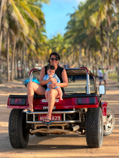Barbara et un jeune enfant à la plage de Porto de Galinhas, à Ipojuca, dans l’état de Pernambuco. Source : Barbara Ramirez. Photo d'une femme portant un jeune enfant sur la plage.
