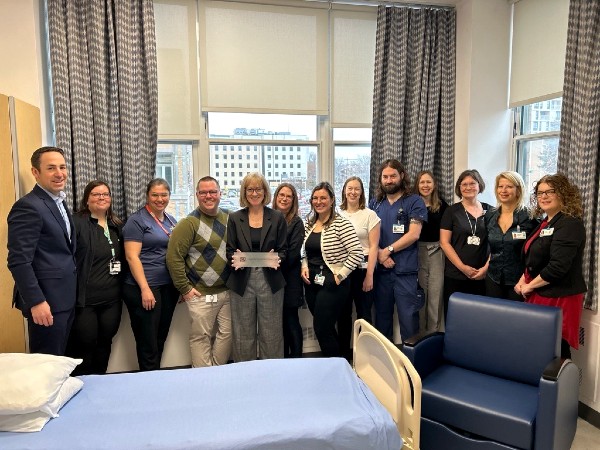 La chambre d'aide médicale à mourir de l'Hôpital du Saint-Sacrement. Sur la photo, de gauche à droite : Francis Morin, vice-président exécutif à la Fondation du CHU de Québec; Amélie Grondin, assistante-infirmière-chef au 1er, 2e et 3e Coulombe, HSS; Sandra Mailloux, infirmière au 1er, 2e et 3e Coulombe, HSS; Jean-Philippe Richard, chef d’unité de soins infirmiers 1er, 2e et 3e Coulombe, HSS; Dre Nathalie Boudreault, adjointe locale à la cheffe du Service de soins palliatifs HSS; Amélie LeBrasseur, agente de planification, de programmation et de recherche à la DMSP; Caryanne Brassard, cheffe d’unité de soins infirmiers 1er, 2e et 3e Coulombe, HSS; Catherine Couture, cheffe d’unité 11 500, L’HDQ; Philippe Whittom, assistant-infirmier-chef 1er, 2e et 3e Coulombe, HSS; Caroline Ménard, adjointe à la directrice de la Direction médecine; Dre Chantale Morency, cheffe du Département de médecine générale; Geneviève Proulx, coordonnatrice médecine et cardiologie à la Direction médecine; Audrey Gagnon, directrice de la Direction médecine. L'équipe qui a rendu l'aménagement possible à HSS.