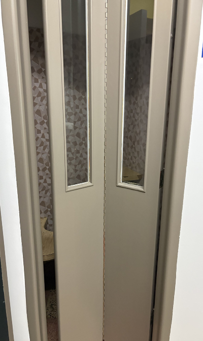 Photo de la porte d'une ancienne cabine téléphonique.