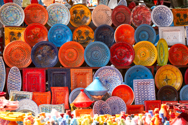 On peut trouver de magnifiques pièces de poterie dans les marchés. Source : Getty Images. Des assiettes colorées sont vendues au marché.