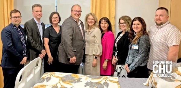 La chambre d'aide médicale à mourir de l'Hôpital de l'Enfant-Jésus. Sur la photo, de gauche à droite : Stéphane Tremblay, ex-directeur des soins critiques; Dr Julien Clément, directeur médical et des services professionnels; Dre Chantale Morency, cheffe du Département de médecine générale; Martin Beaumont, président-directeur général du CHU; Marie-Claude Paré, ex-présidente et cheffe de la direction de la Fondation du CHU; Danielle Goulet, présidente-directrice générale adjointe au CHU; Audrey Gagnon, directrice de la Direction médecine; Julie Nicol, cheffe d’unité de soins infirmiers BE-5000, C5000 et unité de soins virtuels; Jean-Sébastien Leclerc, chef d’unité de soins infirmiers BE-5000, C5000 et unité de soins virtuels. L'équipe qui a rendu l'aménagement possible à HEJ.